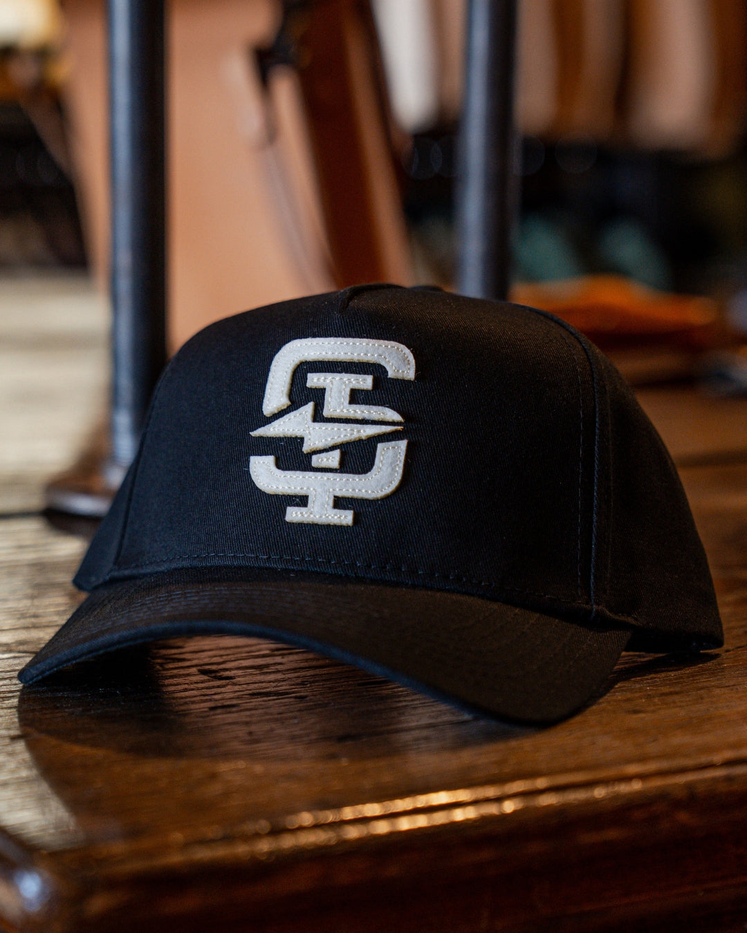 Black Standard Issue cap with a white logo on a wooden surface