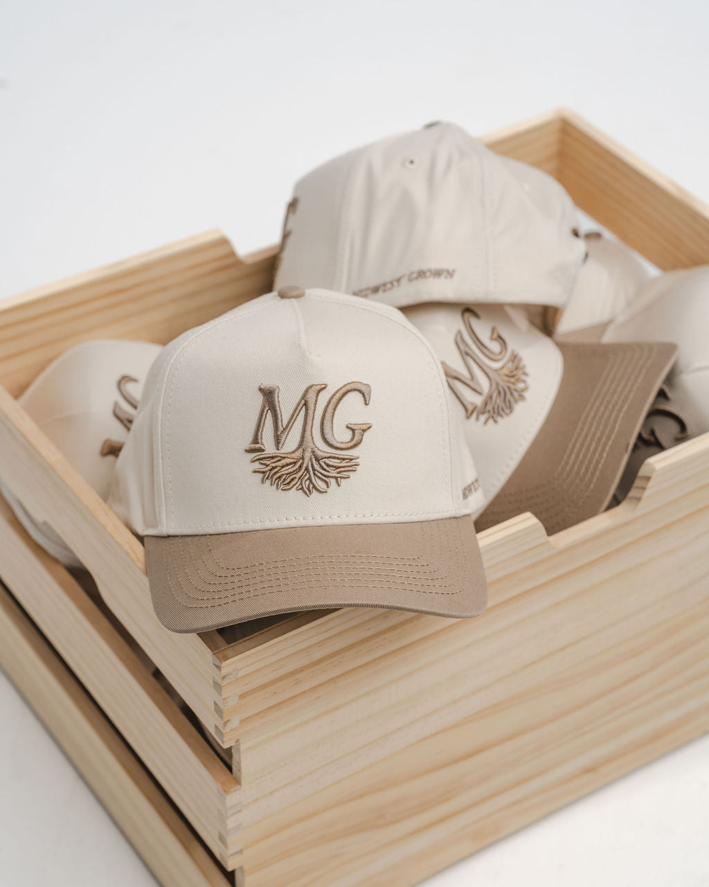 Beige caps with 'Midwest Grown' logo in a wooden box on a white background