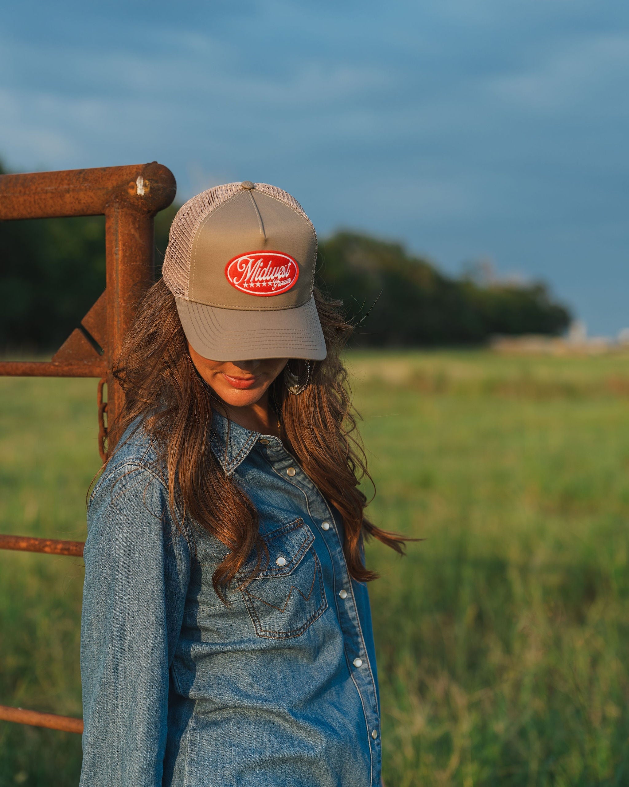 Woman wearing a Midwest Grown Hat with a logo in a field