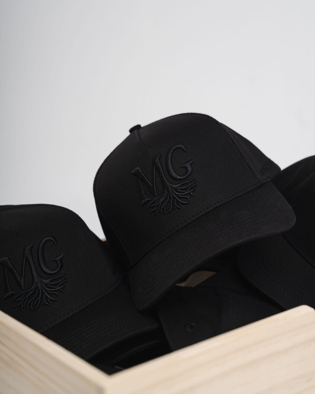 Black caps with a Midwest Grown logo on a light gray background