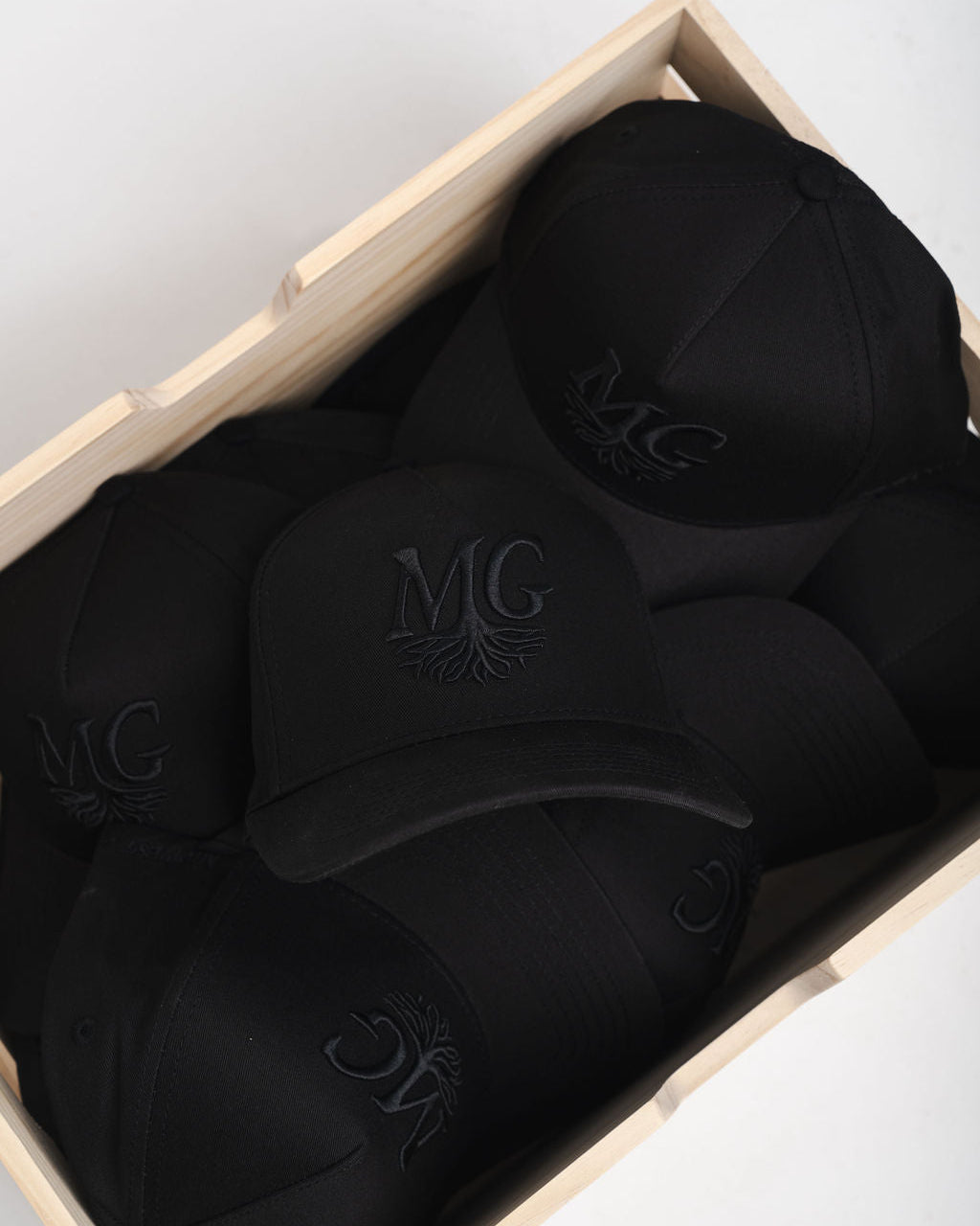 Black caps with a Midwest Grown logo in a box on a light gray background