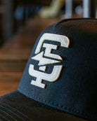 Black cap with a white logo on a blurred background