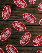 Red and white 'Midwest' logo stickers on a wooden surface