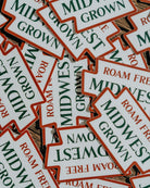 Stack of 'Midwest Grown' and 'Roam Free' stickers.