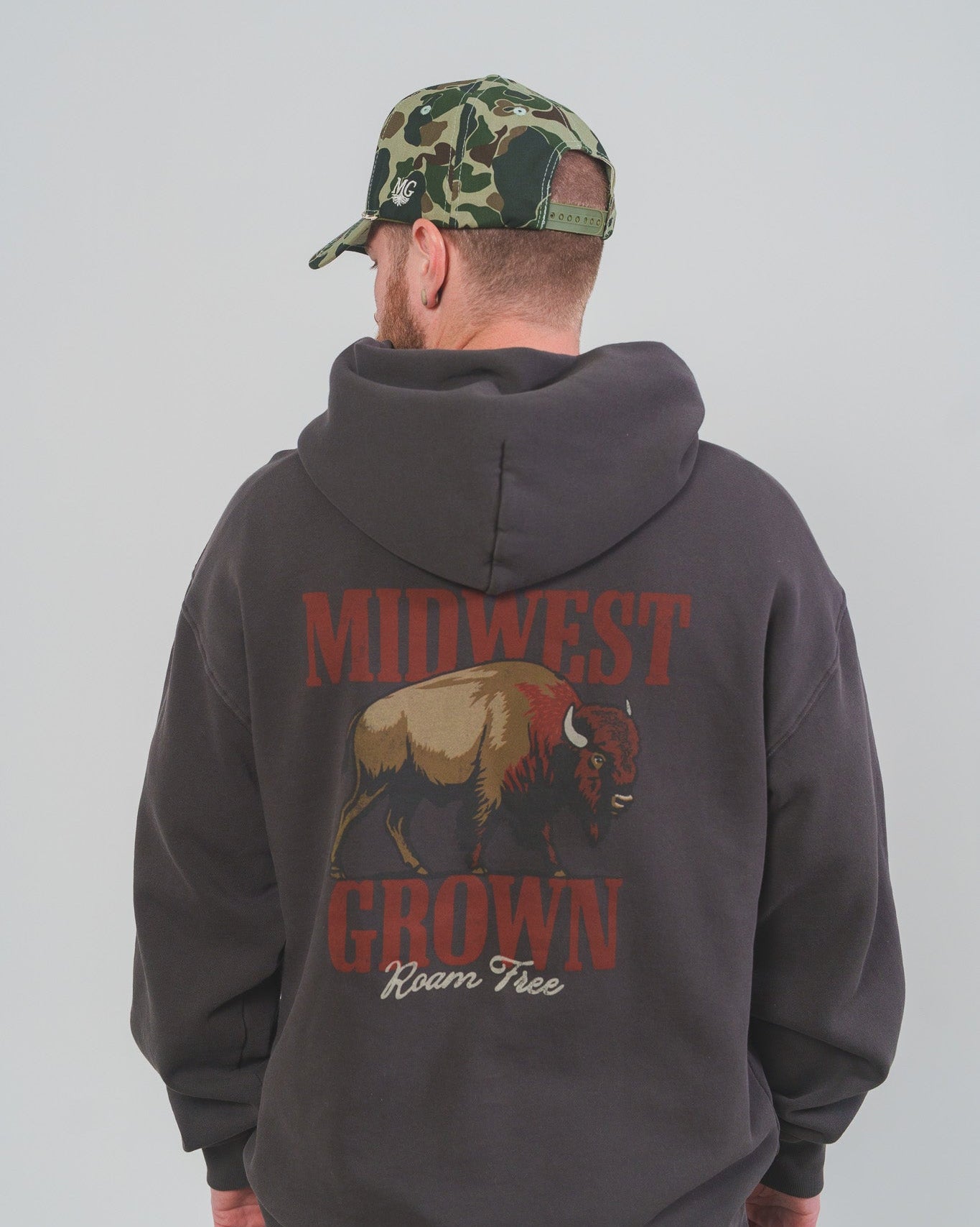 Person wearing a hoodie with 'Midwest Grown' and a bison graphic on the back, standing against a plain background.